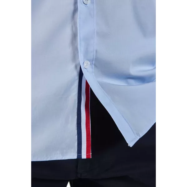 Petit drapeau français accroché en bas à droite de la chemise.