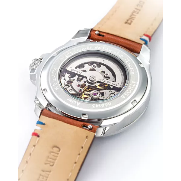 Dos de la montre laissant apparaitre le mécanisme de la montre, détails tricolores brodés sur le bracelet.