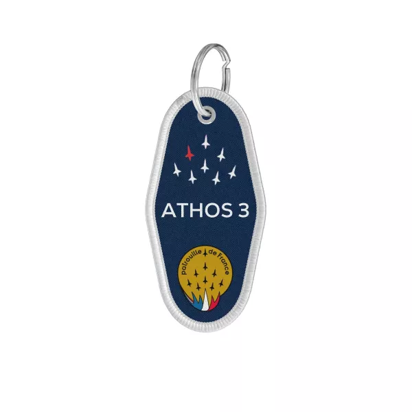 Porte-clé en tissu bleu avec le mot ATHOS 3 écrit en blanc