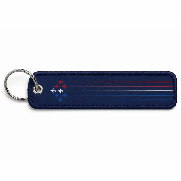 Porte clé en metal avec flamme en tissu de coloris bleu marine, et inscription blanche "Patrouille de France"