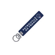 Porte clé en metal avec flamme en tissu de coloris bleu marine, et inscription blanche "Patrouille de France"