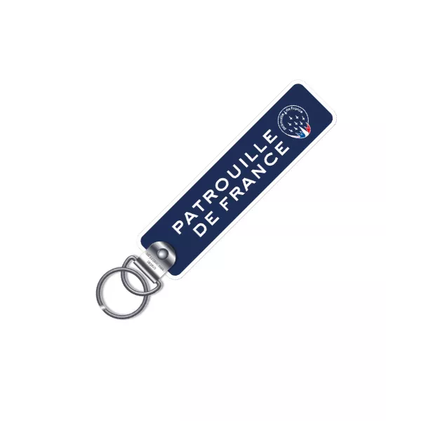 Porte clé en metal avec flamme en tissu de coloris bleu marine, et inscription blanche "Patrouille de France"