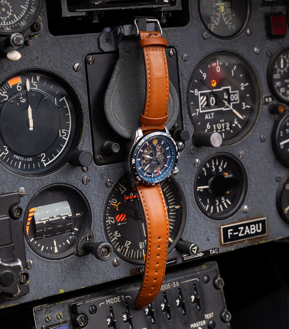 Montre patrouille de France en cuir marron et au cadran bleu, accroché au tableau de bord d'un alphajet