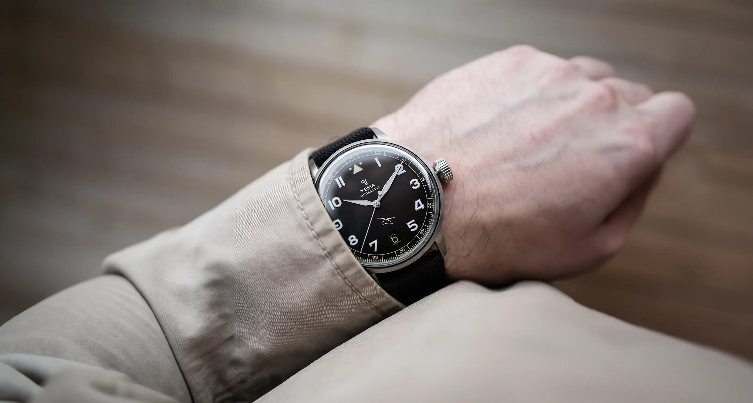 Montre portée au poignet par un homme avec son bracelet et son cadran noir assortis