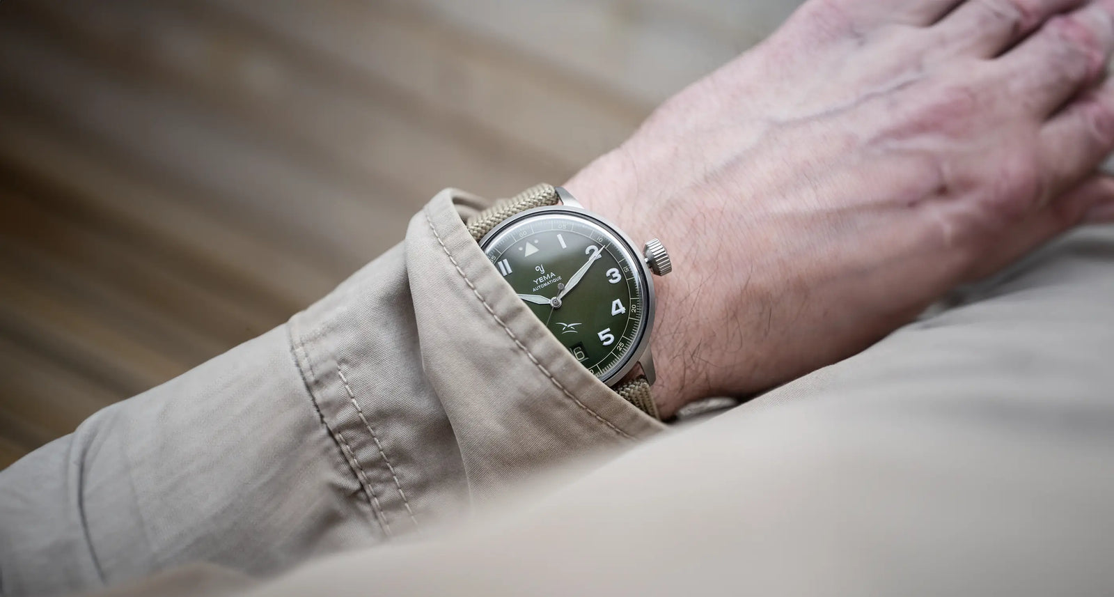 Montre portée au poignet par un homme avec son bracelet et son cadran vert assortis