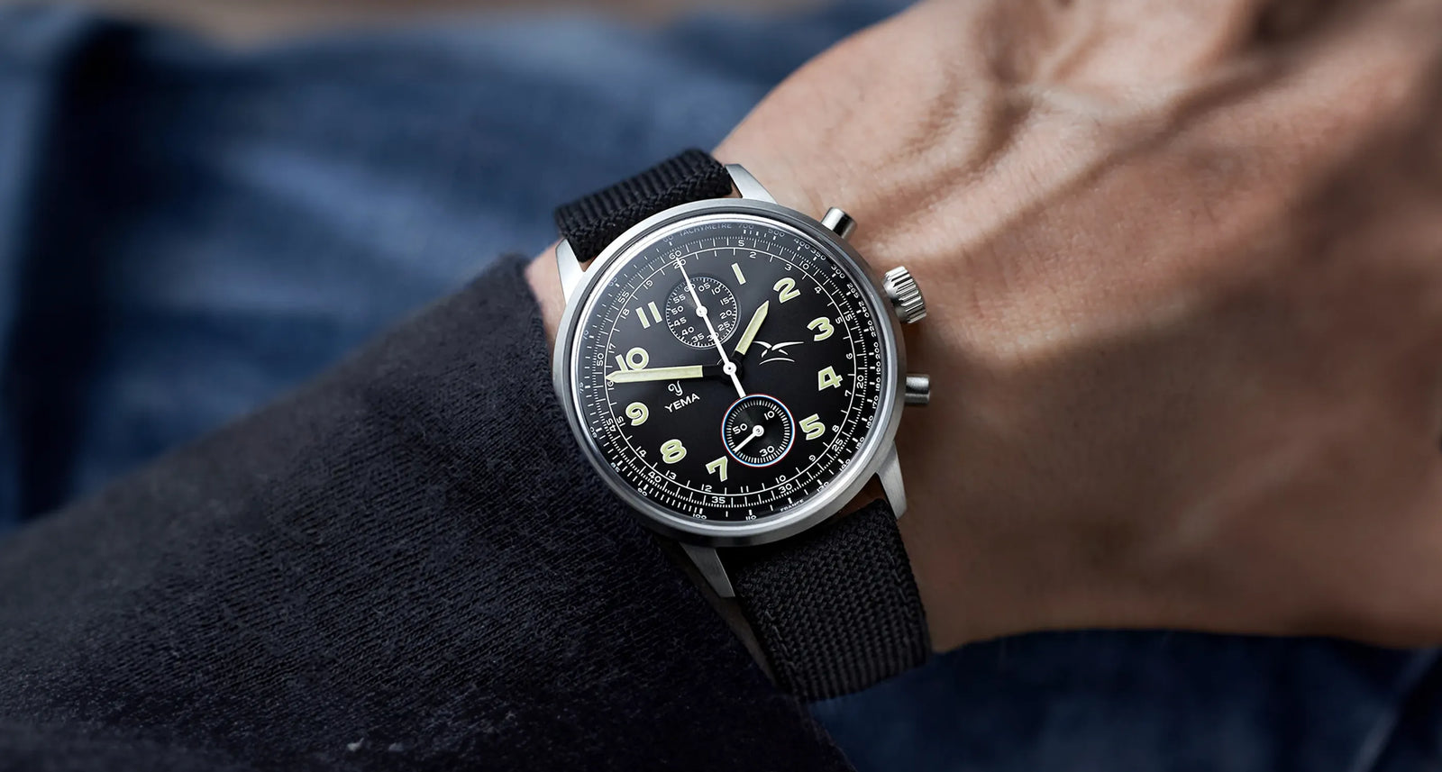 Montre portée au poignet par un homme avec son bracelet et son cadran noir assortis