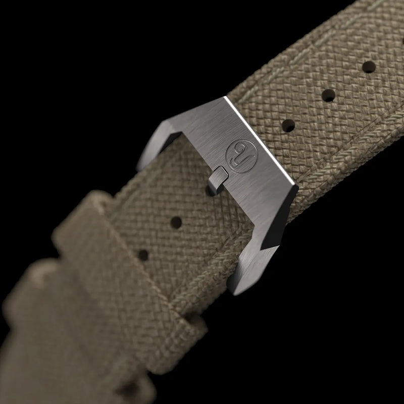Boucle argentée du bracelet en tissu vert kahki, gravée avec le logo Yema.
