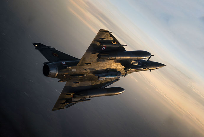 Avion de l'armée de l'air et de l'espace effectuant un vol au couché du soleil
