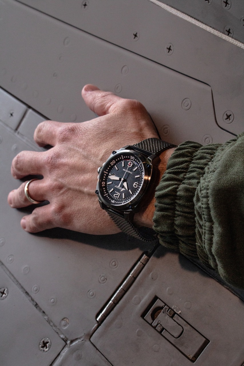 Montre patrouille de France avec bracelet en cuir marron et cadran bleu, posée sur le tableau de bord d'un alpha jet