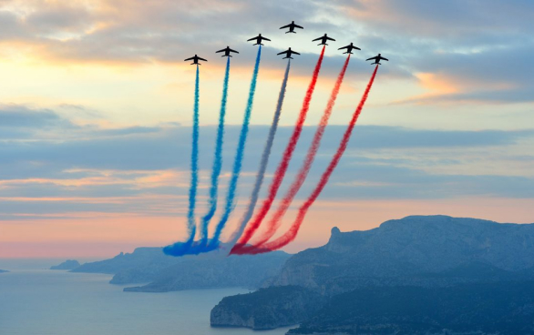 Vol de la patrouille de France avec son panache tricolore, au-dessus de la mer